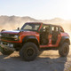 A photo of an orange Ford Bronco Raptor.